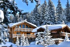 Chalet sous la neige entouré de sapins