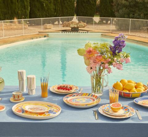 Table devant une piscine avec de la vaisselle du designer Alexandre Benjamin x Monoprix