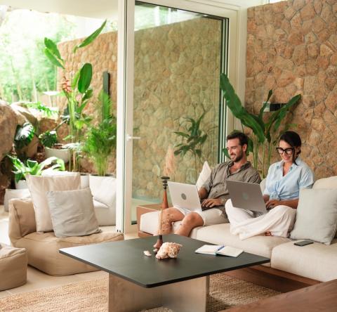 Couple qui travaille dans leur villa de luxe